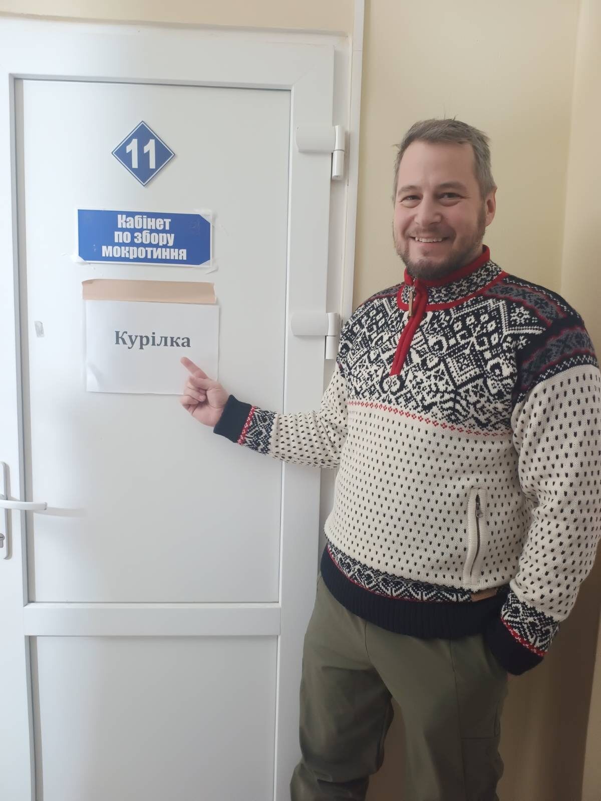 Sklárčik pri dverách č. 11 v nemocnici s ukrajinským nápisom Kabinet na zber spúta, prelepeným papierikom Fajčiareň